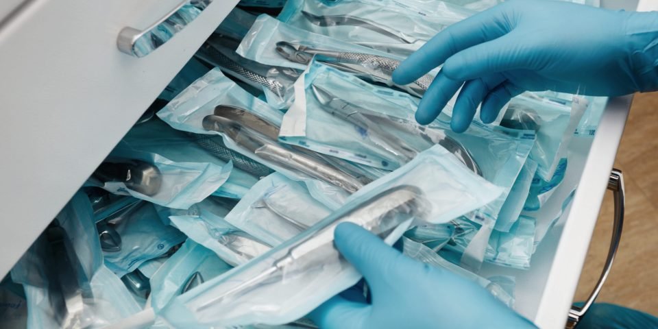 Medical laboratory technician holding a set of sterile disposable instruments